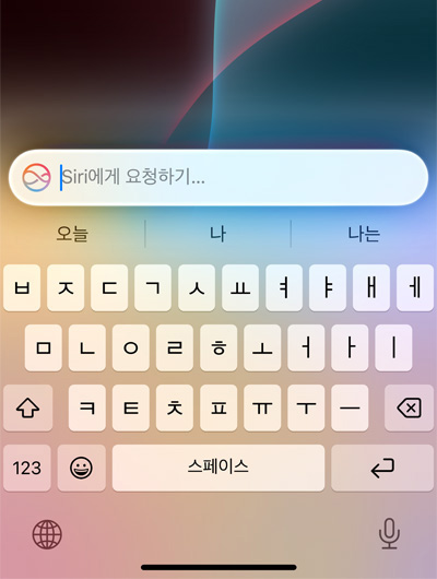 iPhone의 키보드 상단에 Ask Siri라고 적힌 텍스트 필드가 열려 있는 모습