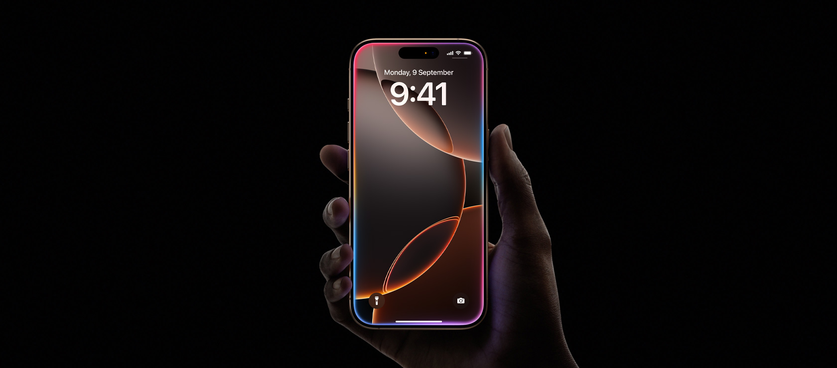 A hand holds iPhone 16 Pro in Desert Titanium, all screen display, Dynamic Island centered near top, rounded corners