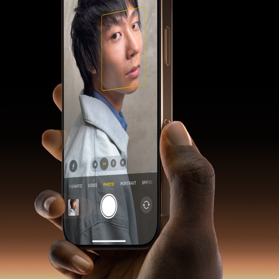 一隻手握著沙漠色鈦金屬 iPhone 16 Pro，拇指在相機控制按鈕上滑動以選擇拍照功能