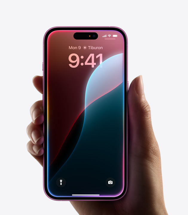 一隻手握著邊緣發出彩色光芒的 iPhone 16。