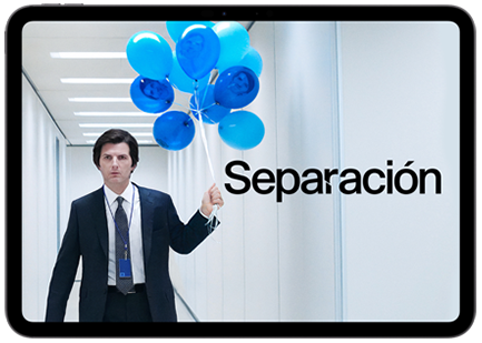 Title, Severance, Adam Scott is standing in a brightly lit office hallway looking focused, wearing a suit with a lanyard, holding strings attached to blue balloons, some of which have his smiling face hand drawn, displayed on iPad