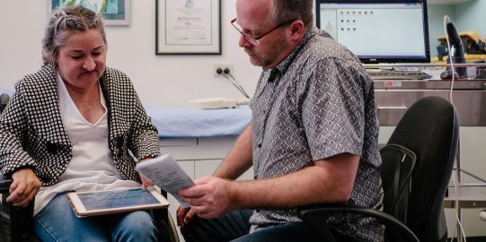 Lisa lets a doctor read what she has written in Proloquo4Text on her iPad